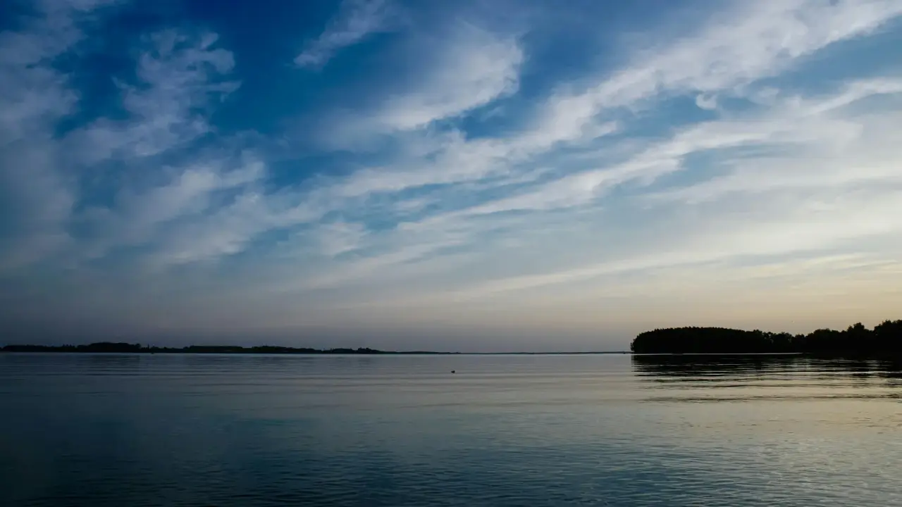 Blick über einen See mit dem gegenüberliegenden Ufer im Hintergrund