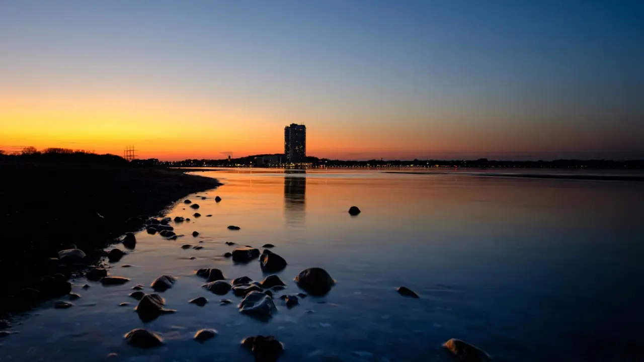 Nahaufnahme von Händen einer Frau, die gerade am Laptop sitzt und im Handy tippt